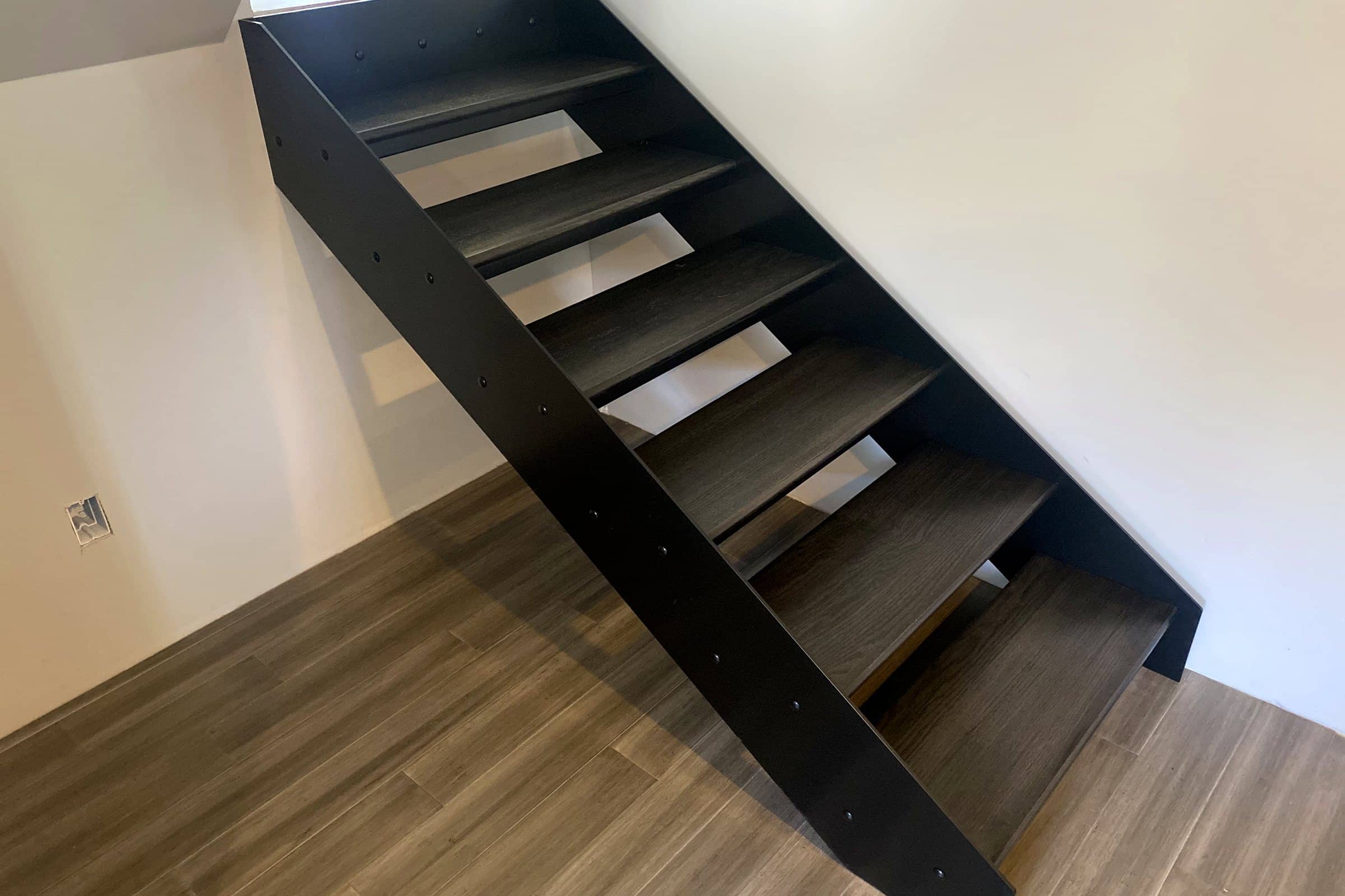 Floating staircase with black steel stringers and oak treads