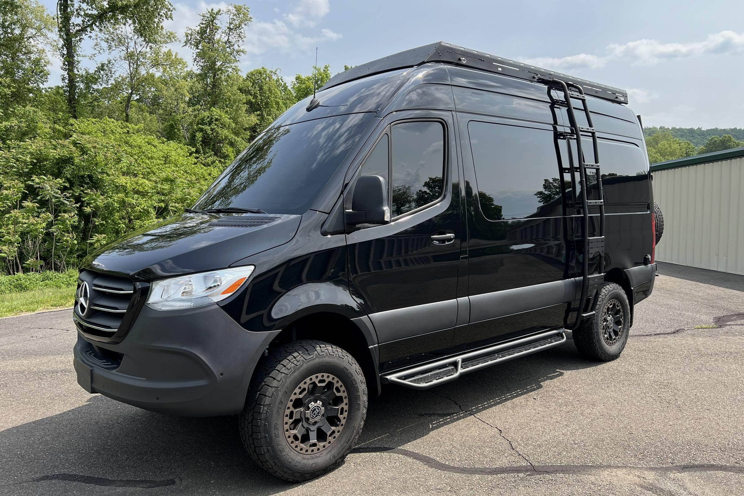 Front three-quarter view of a black 2022 Mercedes Sprinter 4x4 camper van